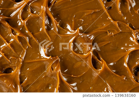 Thick caramel sauce swirl with glossy finish macro. Thick caramel sauce swirl with glossy finish macro. 139638160