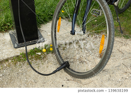 Pumping a bike wheel at an outdoor service point Pumping a bike wheel at an outdoor service point 139638199