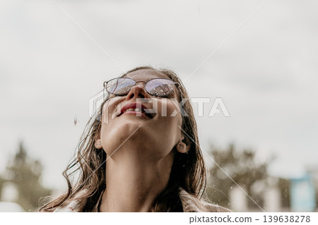 Woman rain glasses looking up at the sky during a rainstorm with copy space and cinematic mood Woman rain glasses looking up at the sky during a rainstorm with copy space and cinematic mood 139638278