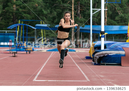 Beautiful female athlete triple jump Beautiful female athlete triple jump 139638625