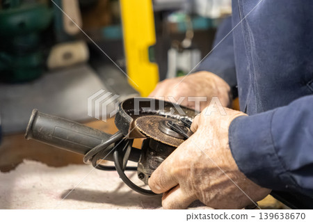 A close up view of a skilled technician changing the grinding disc on an angle grinder, performing essential maintenance for precision metalwork and professional construction tasks A close up view of a skilled technician changing the grinding disc on an angle grinder, performing essential maintenance for precision metalwork and professional construction tasks 139638670
