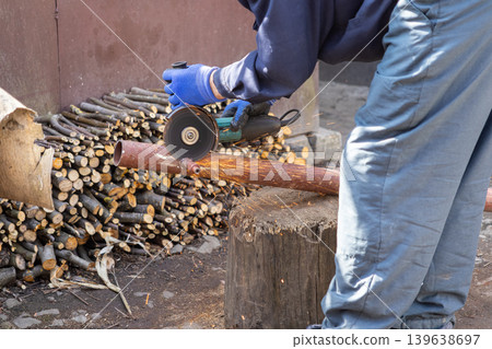 Worker using an angle grinder to cut a metal pipe, demonstrating precision metalworking and industrial maintenance techniques in a workshop environment with bright flying sparks Worker using an angle grinder to cut a metal pipe, demonstrating precision metalworking and industrial maintenance techniques in a workshop environment with bright flying sparks 139638697