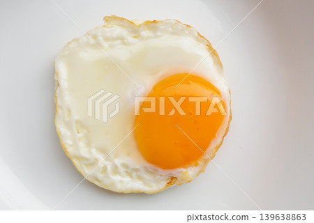 Fried egg on white dish close up Fried egg on white dish close up 139638863