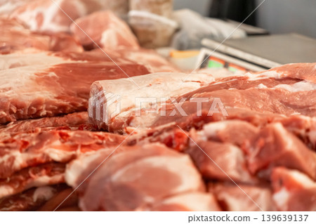 Fresh raw pork meat cuts displayed on a butcher shop counter, representing high quality protein sourcing, culinary preparation, traditional food market retail, and healthy nutrition industry Fresh raw pork meat cuts displayed on a butcher shop counter, representing high quality protein sourcing, culinary preparation, traditional food market retail, and healthy nutrition industry 139639137