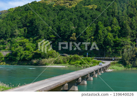 The Kataoka Submersible Bridge spanning the Niyodo River in Kochi Prefecture, and the scenery of the clear stream. The Kataoka Submersible Bridge spanning the Niyodo River in Kochi Prefecture, and the scenery of the clear stream. 139640026