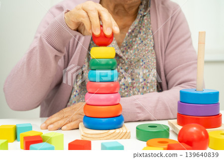 Alzheimer disease AD, Asian elderly woman patient suffering from dementia learn practical motor skills rehabilitation. 139640839