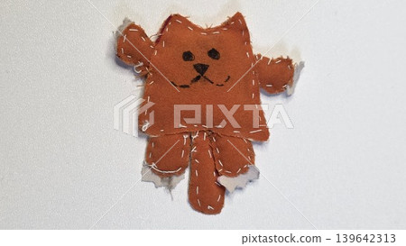 Handmade stitched orange fabric cat toy isolated on white background. Cute clumsy diy craft project made by child representing creative naive textile art and childish imagination. Handmade stitched orange fabric cat toy isolated on white background. Cute clumsy diy craft project made by child representing creative naive textile art and childish imagination. 139642313
