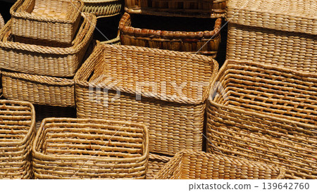 Handmade woven wicker baskets stacked together, natural material storage containers for home organization. Handmade woven wicker baskets stacked together, natural material storage containers for home organization. 139642760