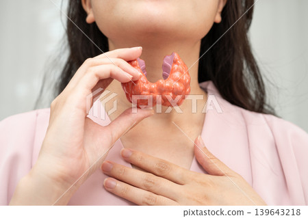 Hyperthyroidism, Overactive Thyroid, Thyroid Lymphoma, Asian woman with thyroid gland human anatomy model. 139643218