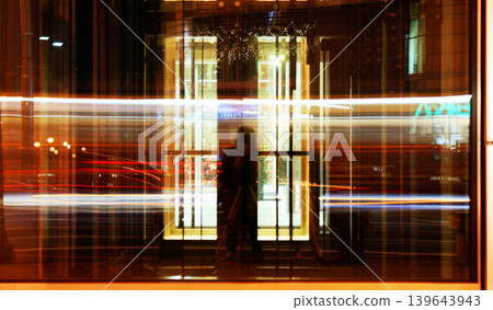 long exposure time reflected in the glass in the city cars are moving fast long exposure time reflected in the glass in the city cars are moving fast 139643943