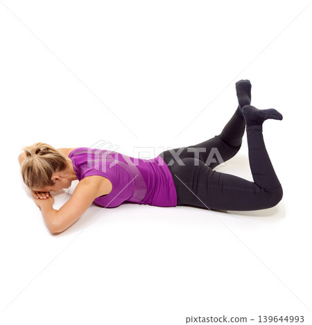 Pilates, woman and stretching thighs, hips and glutes on the floor in white background of studio. Yoga, exercise and person workout for legs on ground with feet raised in the air in pose for fitness Pilates, woman and stretching thighs, hips and glutes on the floor in white background of studio. Yoga, exercise and person workout for legs on ground with feet raised in the air in pose for fitness 139644993