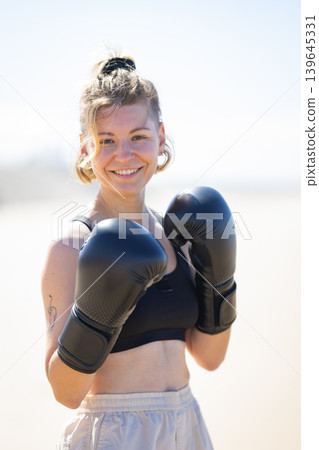 Young woman smiling ready for boxing training outdoors Young woman smiling ready for boxing training outdoors 139645331