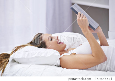 Excited woman, bedroom and tablet for online streaming, reading news or watch funny video on social media. Young person relax on bed with wow, happy or laughing on digital technology or web at home Excited woman, bedroom and tablet for online streaming, reading news or watch funny video on social media. Young person relax on bed with wow, happy or laughing on digital technology or web at home 139645341
