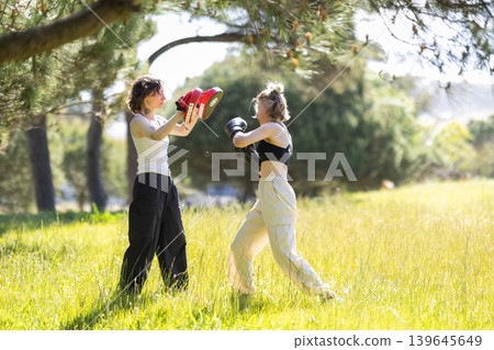Women training boxing in outdoor park for fitness Women training boxing in outdoor park for fitness 139645649