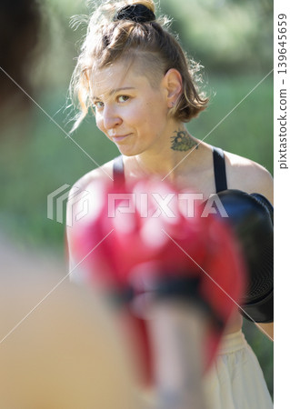 Woman boxer training with focus and determination Woman boxer training with focus and determination 139645659