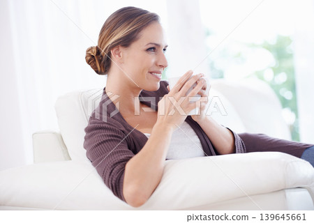 Thinking, coffee and happy woman relax on a sofa with memory, moment or reflection in her home. Tea, break and female person in a living room with comfort, beverage or day off, me time or self care Thinking, coffee and happy woman relax on a sofa with memory, moment or reflection in her home. Tea, break and female person in a living room with comfort, beverage or day off, me time or self care 139645661