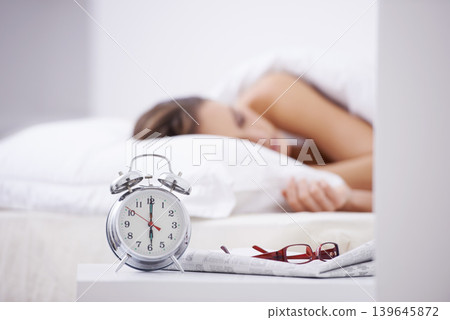 Sleeping, morning and woman in bed with alarm for snooze, wake up and start day in home. Lazy, tired and person resting, dreaming and relaxing in bedroom with time, clock and glasses in house Sleeping, morning and woman in bed with alarm for snooze, wake up and start day in home. Lazy, tired and person resting, dreaming and relaxing in bedroom with time, clock and glasses in house 139645872