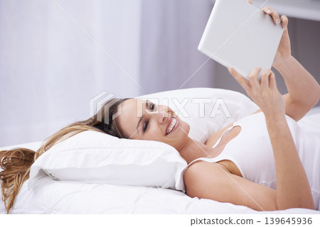 Happy woman, bed and relax with tablet for social media, communication or networking at home. Female person smile lying in bedroom on pillow with technology for online streaming or entertainment 139645936
