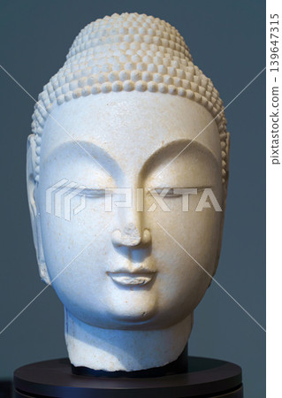 Abu Dhabi, United Arab Emirates - Jan 17 2024, close up view of the ancient head of the statue of a budda, on exhibition of museum Louvre Abu Dhabi, UAE Abu Dhabi, United Arab Emirates - Jan 17 2024, close up view of the ancient head of the statue of a budda, on exhibition of museum Louvre Abu Dhabi, UAE 139647315