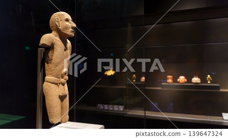 Abu Dhabi, United Arab Emirates - Jan 17 2024, close-up view of the stone Aztec sculpture of a man, in the background there are other exhibits of the museum Louvre Abu Dhabi, UAE 139647324