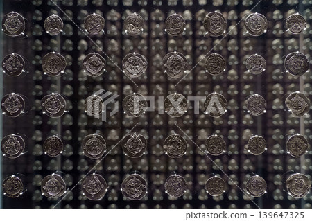 Abu Dhabi, United Arab Emirates - Jan 17 2024, Close-up view of showcase with many antique coins with a mirror reflecting them many times, Louvre Abu Dhabi Museum, Abu Dhabi, United Arab Emirates 139647325