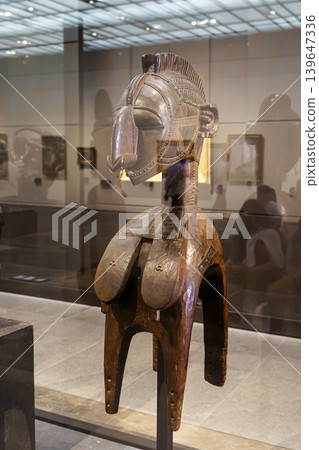 Abu Dhabi, United Arab Emirates - Jan 17 2024, close-up view of the showcase in which there is a Nimba, a wooden shoulder mask from Guinea, on exhibition of museum Louvre Abu Dhabi, UAE 139647336