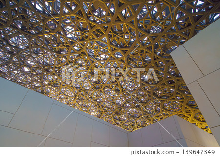 Abu Dhabi, United Arab Emirates - Jan 17 2024, Panoramic view of the metallic dome and buildings of the Louvre Abu Dhabi Museum, at daytime, Abu Dhabi, United Arab Emirates Abu Dhabi, United Arab Emirates - Jan 17 2024, Panoramic view of the metallic dome and buildings of the Louvre Abu Dhabi Museum, at daytime, Abu Dhabi, United Arab Emirates 139647349