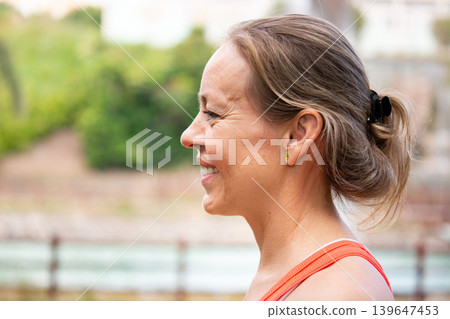 Side profile portrait of smiling mature woman during outdoor workout 139647453