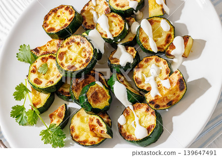 Fried zucchini with garlic yogurt sauce on plate Fried zucchini with garlic yogurt sauce on plate 139647491