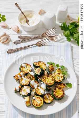 Fried zucchini with garlic yogurt sauce on plate Fried zucchini with garlic yogurt sauce on plate 139647495