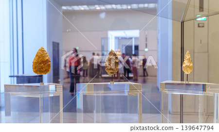Abu Dhabi, United Arab Emirates - Jan 17 2024, Close-up view of three ancient flint blades, the background is blurred, on exhibition of the Louvre Abu Dhabi, UAE Abu Dhabi, United Arab Emirates - Jan 17 2024, Close-up view of three ancient flint blades, the background is blurred, on exhibition of the Louvre Abu Dhabi, UAE 139647794