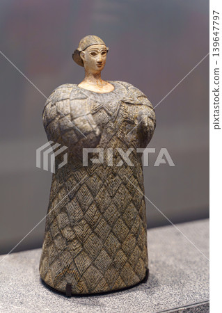 Abu Dhabi, United Arab Emirates - Jan 17 2024, close-up view of the exhibit, an ancient statuette of a woman in a wool dress, on exhibition of museum Louvre Abu Dhabi, UAE Abu Dhabi, United Arab Emirates - Jan 17 2024, close-up view of the exhibit, an ancient statuette of a woman in a wool dress, on exhibition of museum Louvre Abu Dhabi, UAE 139647797