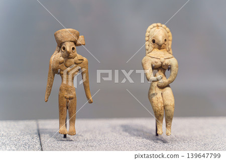 Abu Dhabi, United Arab Emirates - Jan 17 2024, Close-up view of two ancient statuettes of women, deities, with necklace, on exhibition of museum Louvre Abu Dhabi, UAEe 139647799