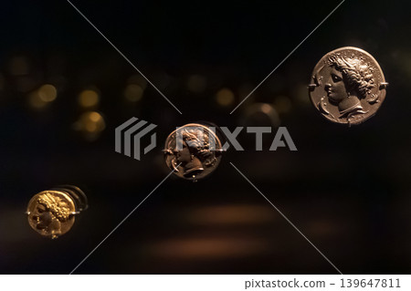 Abu Dhabi, United Arab Emirates - Jan 17 2024, Close-up view of the ancient antique coins in the Louvre Abu Dhabi Museum, belonging to different eras, Abu Dhabi, United Arab Emirates Abu Dhabi, United Arab Emirates - Jan 17 2024, Close-up view of the ancient antique coins in the Louvre Abu Dhabi Museum, belonging to different eras, Abu Dhabi, United Arab Emirates 139647811