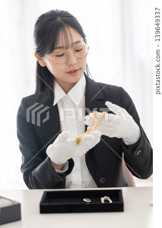 戴著白手套的日本女性，在二手商店/回收店鑑定貴金屬。 139649337