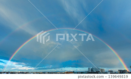 A perfect rainbow arch stretches across the city sky after the rain. A perfect rainbow arch stretches across the city sky after the rain. 139649819