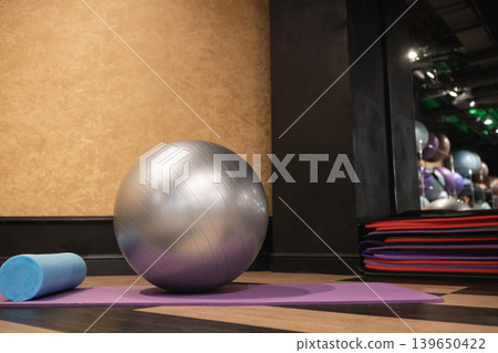 Fitness ball and foam roller on yoga mat in gym 139650422