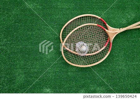 Vintage badminton rackets and shuttlecock on green grass top view Vintage badminton rackets and shuttlecock on green grass top view 139650424