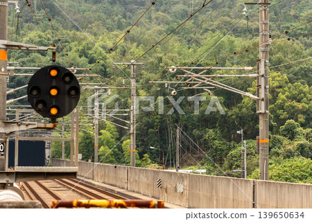 A railway viaduct running through a mountainous area, with signal equipment (relay signals) – a typical scene of Japanese railway infrastructure. 139650634