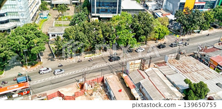 View of a city intersection with office buildings and traffic during the day 139650755