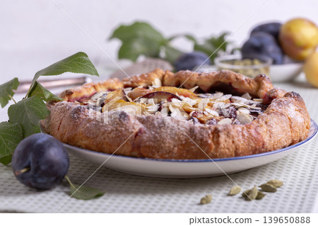 Open pie (galette) with plums and cardamom. Open pie (galette) with plums and cardamom. 139650888