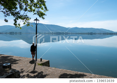Greece, Kastoria: Woman gazing at Lake Orestiada in Kastoria, Greece Greece, Kastoria: Woman gazing at Lake Orestiada in Kastoria, Greece 139651639