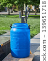 Blue plastic barrel with volume of one hundred liter standing on industrial pallet cart outdoors. Storage container for liquid or solid materials. Equipment for logistics facility. 139651718