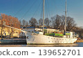 Porvoo, Finland - December 08, 2020: Historic sailing ship is docked by the waterfront, surrounded by trees and buildings, showcasing maritime heritage and urban scenery 139652701