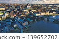Porvoo, Finland - December 08, 2020: Aerial view showcases a vibrant town along the river, featuring colorful houses, a bridge, and scenic landscapes under a cloudy sky 139652702