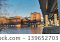 Porvoo, Finland - December 08, 2020: Historic wooden structures line the riverbank, with a bridge overhead creating a unique urban landscape and inviting atmosphere 139652703
