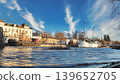 Porvoo, Finland - December 08, 2020: Scenic waterfront view features boats docked along the shore, with a vibrant blue sky and wispy clouds creating a picturesque atmosphere 139652705
