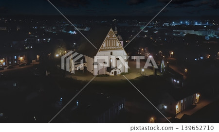 Porvoo, Finland - December 08, 2020: Aerial view of a historic church illuminated at night, surrounded by a charming town, showcasing architectural beauty and serene ambiance Porvoo, Finland - December 08, 2020: Aerial view of a historic church illuminated at night, surrounded by a charming town, showcasing architectural beauty and serene ambiance 139652710
