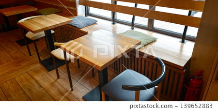Cozy cafe interior with wooden tables and benches during daytime 139652883