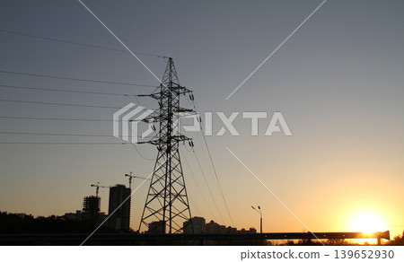 Silhouette of high voltage power line tower with building construction background Silhouette of high voltage power line tower with building construction background 139652930